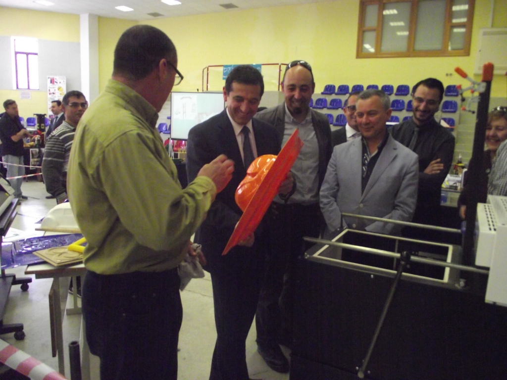 Hon. Chris Agius Parliamentary Secretary for Youth and Innovation experiencing the vaccum forming process and moulding a robotic face mask designed by DTLC design and  support team staff. 
